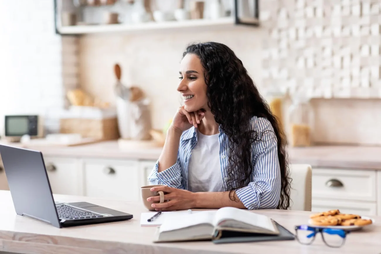 Mujer revisando su declaración de la renta con una sonrisa, tras beneficiarse de un plan de retribución flexible y conseguir un mayor ahorro fiscal.
