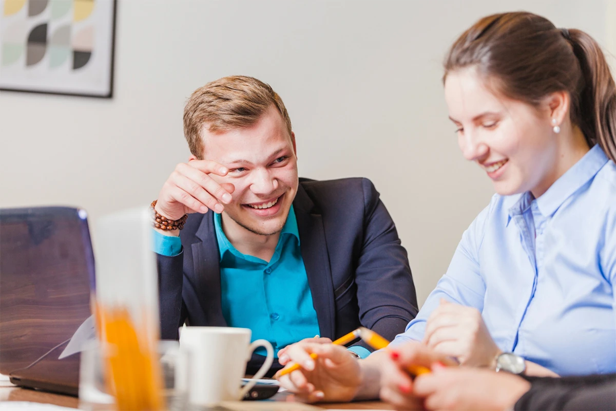 Dos profesionales revisando documentos en una oficina mientras conversan, representando la implementación de un plan de retribución flexible en una empresa.